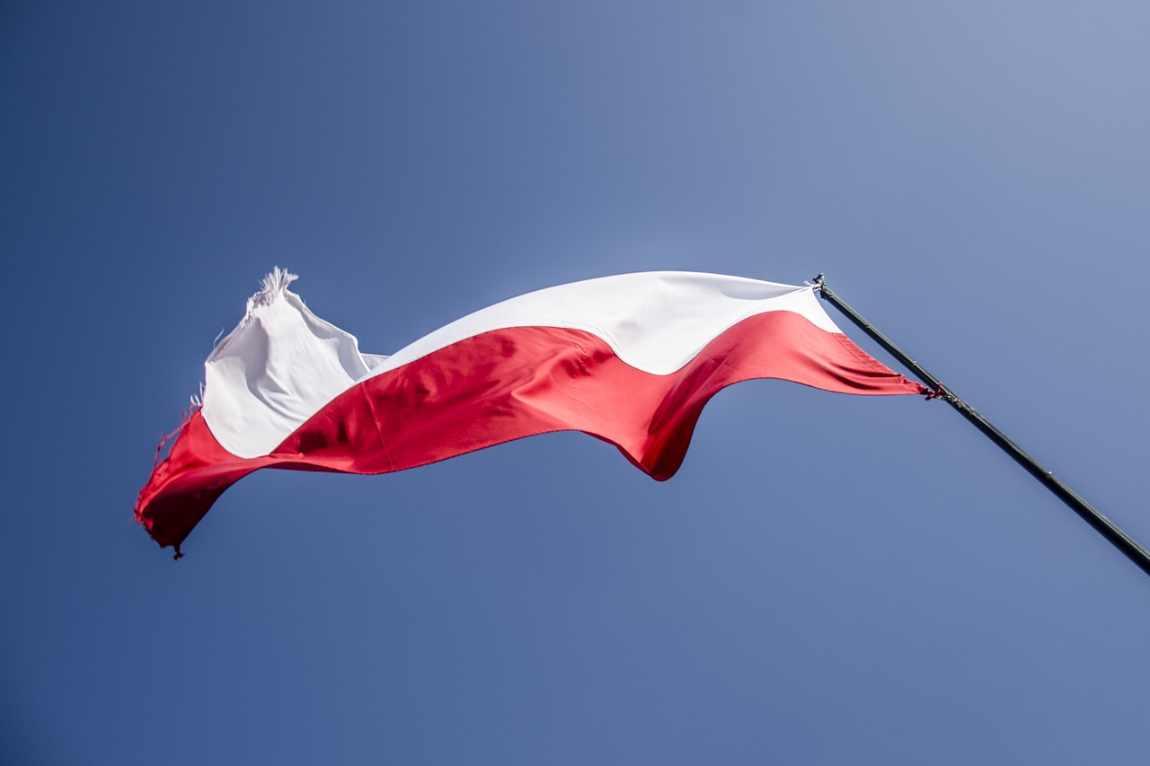 polska bandera na wietrze i błekitnym niebie